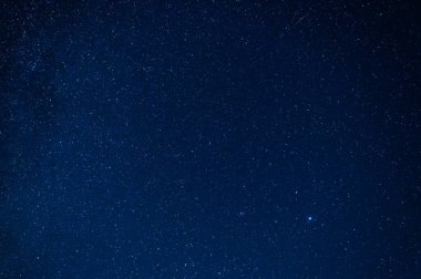 Koyu mavi yıldızlı gökyüzünün gökyüzü birçok yıldız, nebula ve galaksi barındırıyor.