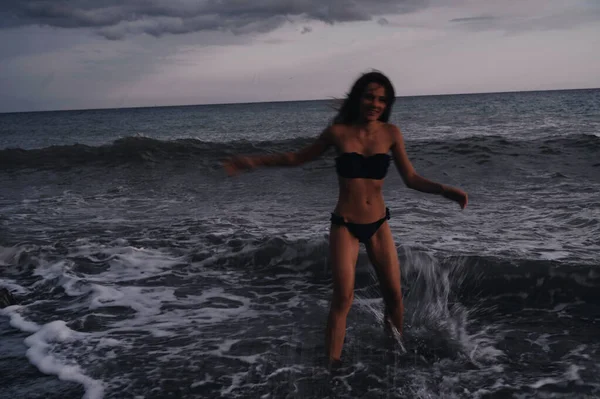 Счастливая молодая девушка в купальнике наслаждается свободой и жизнью на пляже у моря — стоковое фото