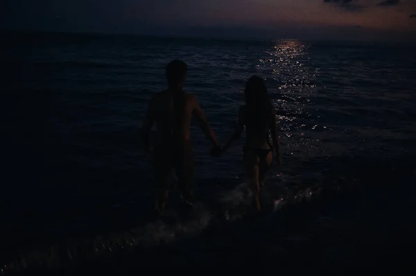 Pareja desnuda en el amor románticamente ir a nadar por la noche en el mar por la playa en verano bajo la luz de la luna —  Fotos de Stock