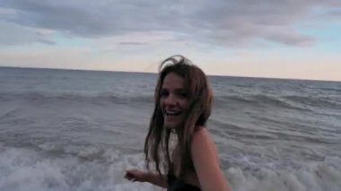 Mayolu genç seksi kadın yaz akşamları sahilde hayatın tadını çıkarıyor. Çift kavramını takip et.
