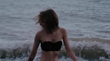 Mayolu genç seksi kız, deniz kenarında gülüyor ve eğleniyor.