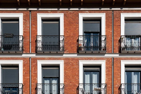 Fachada de ladrillo naranja con balcones de hierro forjado — Foto de Stock