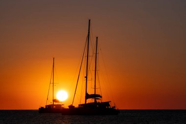 Akdeniz 'de gün batımında iki yelkenli silueti.