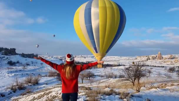 Una joven en las montañas ve una bola multicolor y extiende sus brazos para deleitarse con el saludo. — Vídeos de Stock