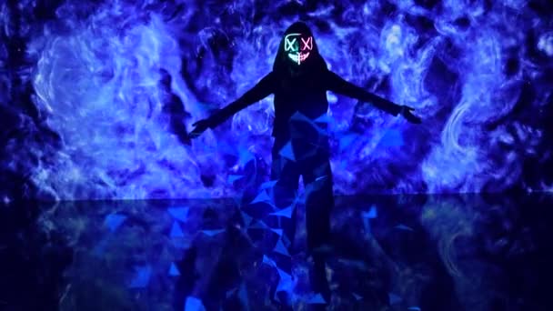 Pessoa anônima em neon brilho máscara levanta as mãos no fundo digital azul. — Vídeo de Stock