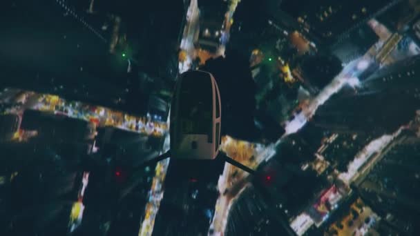 Luftaufnahme eines Drohnen-Taxis, das nachts über der modernen Stadt fliegt. — Stockvideo