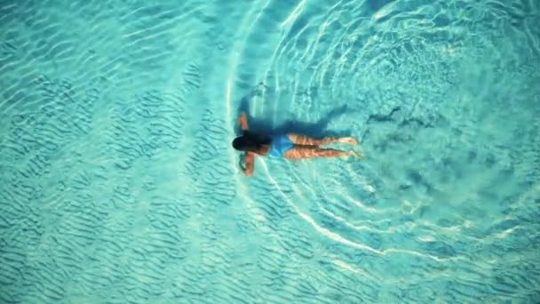 Aerial slow-motion video of young woman swims at the crystal ocean water. Royalty Free Stock Footage