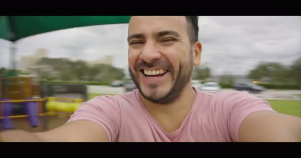 Dad having fun and smiling at camera while spinning in merry go round — Stock Video