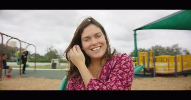 Zeitlupe einer fröhlichen Frau, die lächelnd die Arme in die Höhe reißt — Stockvideo