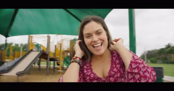 Perempuan tersenyum di kamera sambil berputar dalam riang pergi bulat — Stok Video