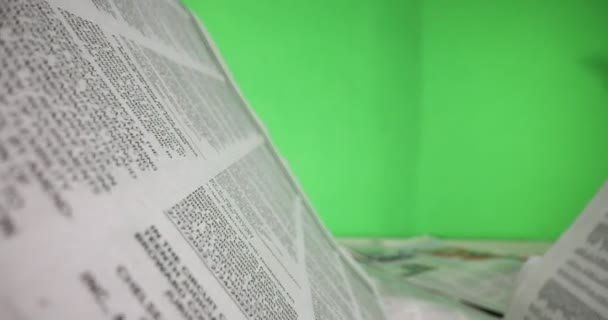Macro shot of newspaper article in front of green screen — ストック動画