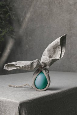 Paskalya arkaplanı, yumurta ve keten peçeteden yapılmış Paskalya tavşanı. Paskalya için ev dekorasyonu. Masa dekorasyonu.