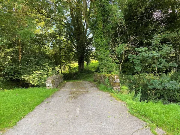 从Hellifeld路 Hellifeld Road 到博尔顿 Bolton 的狭窄乡间小路 Cul Sac 有一座古老的石桥和一些树木 — 图库照片