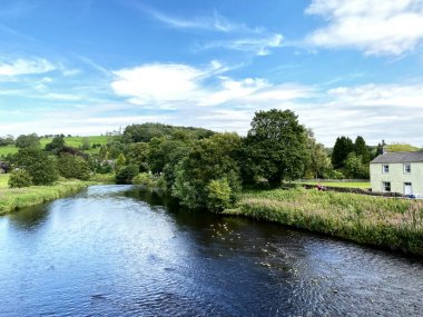 Ribble Nehri 'ne bakıyorum, eski taş köprüden, uzaktaki ağaçlar, evler ve tepelerle, Sawley, Clitheroe, İngiltere