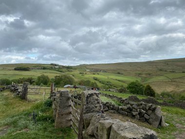 Fırtınalı hava, güneşin yağmur bulutlarının arasından geçmesiyle Haworth, Keighley, İngiltere