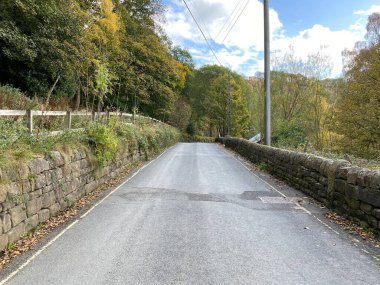 Midgehole Yolu, kuru taş duvarlar ve yaşlı ağaçlarla, bulutlu bir sonbahar öğleden sonra, Heptonstall, Yorkshire, İngiltere