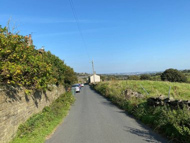 Aşağı bak, Alderscholes Yolu, çiçekler, tarlalar ve uzak mesafedeki evler, Thornton, Bradford, İngiltere