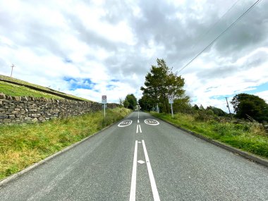 Otley Yolu 'na bakıyorum. Kuru taş duvarlar, ağaçlar ve bulutlu bir gökyüzü var. Bingley, Bradford, İngiltere yakınlarında.