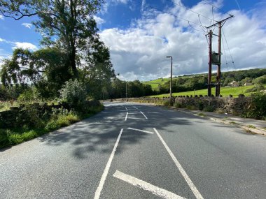 Otley Yolu boyunca, kuru taş duvarlar, eski ağaçlar ve yakınlardaki bulutlu gökyüzü, Doğu Morton, Bradford, İngiltere