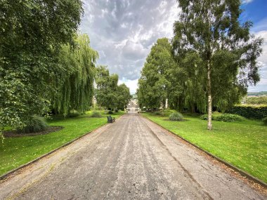 Parkland, eski ağaçlar, geniş patika ve bulutlu gökyüzü Bradford, Yorkshire, İngiltere