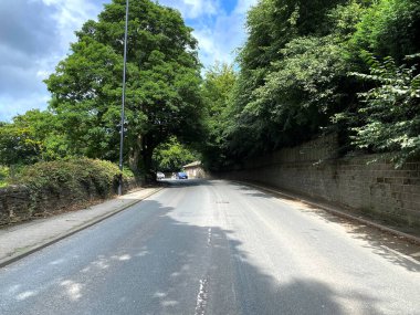 Apperley Yolu 'nun yukarısında eski ağaçlar, taş duvarlar ve Rawdon, Leeds, İngiltere' ye gelen bir araba var.