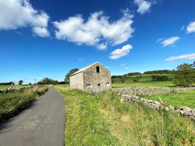 Skipton Yolu 'ndaki terk edilmiş ahır. Kuru taş duvarlar, yabani bitkiler ve Fewston, Harrogate, İngiltere' deki tarlalar.