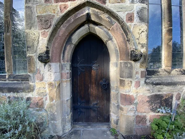 非常に古い アーチ型の教会のドアは ヨークシャー スキプトンの風化した石に囲まれて — ストック写真