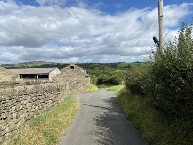 Aşağı bak, Lumb Gill Lane, kuru taş duvarları ve ek binaları olan, Addingham, Ilkley, İngiltere