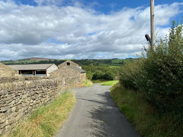 Aşağı bak, Lumb Gill Lane, kuru taş duvarları ve ek binaları olan, Addingham, Ilkley, İngiltere