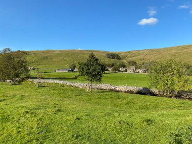 Tarlaların, çayırların ve kuru taş duvarların arasından Halton Gill, Skipton, İngiltere yakınlarındaki çiftlik ve kulübelere bakın.