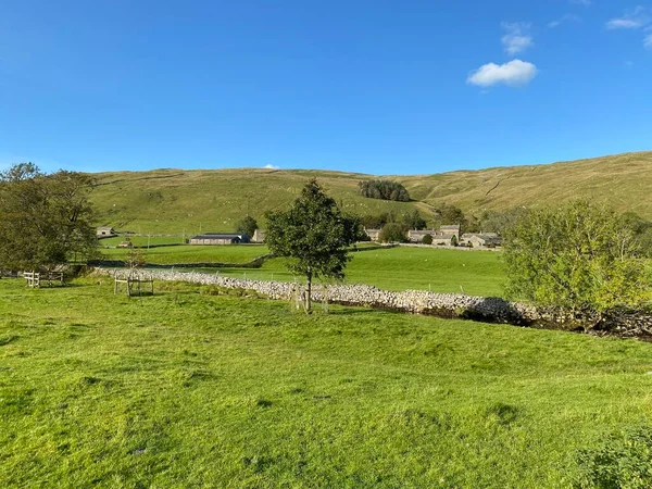 Tarlaların, çayırların ve kuru taş duvarların arasından Halton Gill, Skipton, İngiltere yakınlarındaki çiftlik ve kulübelere bakın.