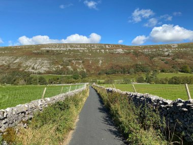 Aşağı bakıyor, Out Gang Lane, kuru taş duvarlarla, Hawkswick, Skipton, İngiltere 'ye iniyor.