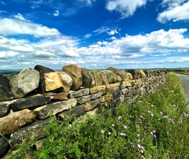 Oxenhope, Keighley, İngiltere yakınlarındaki Long Causeway yolunda yeni restore edilmiş kuru taş duvar.