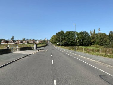 Smithy Köprüsü Yolu, evler, eski ağaçlar ve Rochdale, Lancashire, İngiltere yakınlarında mavi bir gökyüzü.