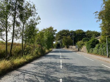 Halifax Yolu boyunca, eski ağaçlar, çimen kenarları ve Rochdale, Lancashire, İngiltere yakınlarında mavi bir gökyüzü.