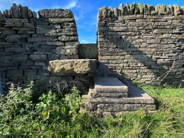 Bradford, İngiltere 'deki Onbaşı Yolu' ndaki kuru bir taş duvar arasındaki araziye giriş izni veren taş adımlar.