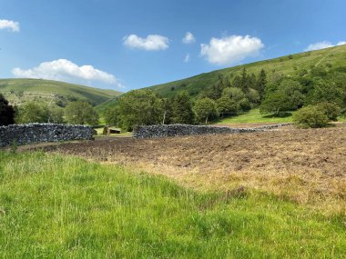 Tepelere bak, tarlalı bir tarlayı geç, kuru taş duvardaki boşluktan bak, Buckden, Skipton, İngiltere yakınlarındaki uçurumlara bak.
