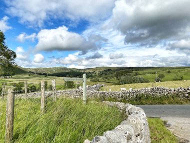 Chapel Gate yolu, Malham 'a çıkıyor, kuru taş duvarlar, tarlalar, tepeler ve ağaçlarla, Airton, Skipton, İngiltere