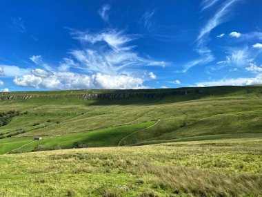 Cray tepelerinin geniş bir manzarası var, bir ahırı ve Buckden, Skipton, İngiltere yakınlarında mavi bir gökyüzü var.