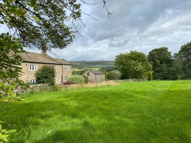 Bolton Abbey 'den, Hetton' dan, Skipton 'dan İngiltere' ye uzanan yemyeşil bir çayıra, ağaçların ve çiftliğin ötesine bakıyorum.