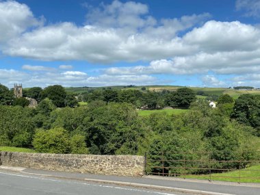 Cowling köyü boyunca, uzak mesafede bir kilise, ağaçlar, tarlalar ve tepeler, Cowling, Keighley, İngiltere