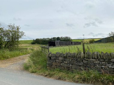 Old farm outbuildings, within  dry stone walls, and an open gate, high on the hills above, Sowerby Bridge, Yorkshire, UK