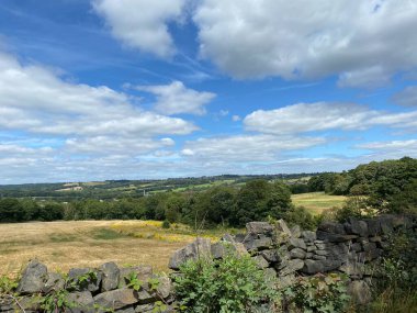 Landscape view, over a dry stone wall, with fields, meadows and trees in, Mirfield, Yorkshire, UK