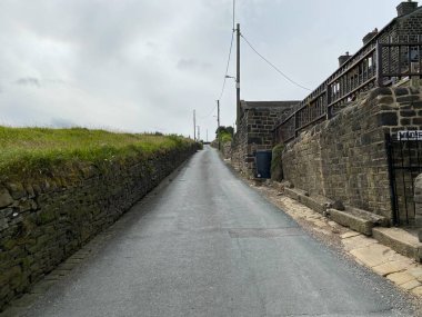 Steep lane, with houses to one side, and fields to the other in, Sowerby Bridge, Uk