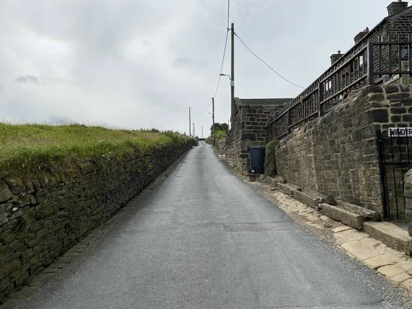 Steep lane, with houses to one side, and fields to the other in, Sowerby Bridge, Uk