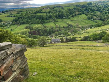 Landscape view over Shibden Valley, with fields, meadows, and trees in the distance, on a cloudy day in, Shibden Valley, Halifax, UK