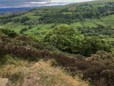 Landscape view, across Shibden Valley, with hills, fields, and trees, on a cloudy day in, Halifax, Yorkshire, UK