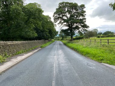 Road leading down to Otley, from Lindley, with dry stone walls and trees