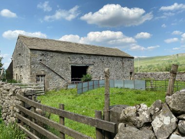 Old farm barn, with dry stone walls, and wooden fencing in, Kilnsey, Skipton