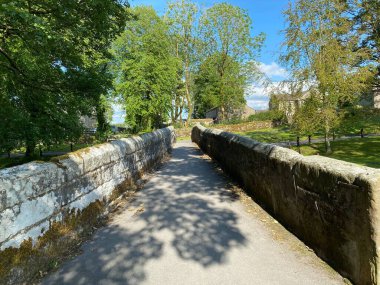 Old stone bridge, for pedestrians, crossing over the beck in, Linton, Skipton, UK